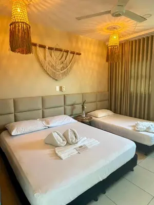 two beds in a bedroom with two towels on them at Awa De Mar Hotel Tolu in Tolú