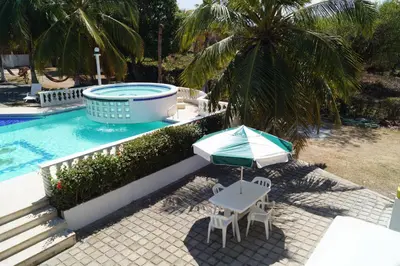 a table and an umbrella next to a swimming pool at Condominio Punta Bolivar in San Antero