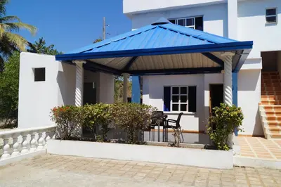 a blue roofed gazebo in front of a house at Condominio Punta Bolivar in San Antero