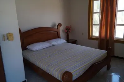 a bedroom with a bed with a striped blanket and two pillows at Condominio Punta Bolivar in San Antero