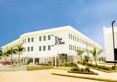 a white building with a fence in front of it at Hotel Las Olas Mamonal in Cartagena de Indias