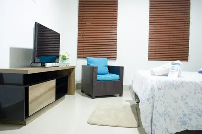 a bedroom with a bed and a tv and a chair at Hotel Las Olas Mamonal in Cartagena de Indias