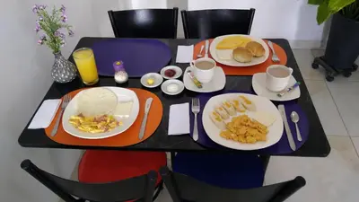 a table with plates of breakfast food on it at Hotel Cosmos Sincelejo in Sincelejo