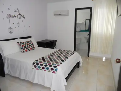 a bedroom with a bed and a bathroom at Hotel Cosmos Sincelejo in Sincelejo