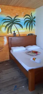 a bedroom with a bed with two palm trees on the wall at Nuestros Tres Tesoros II in Playa Blanca