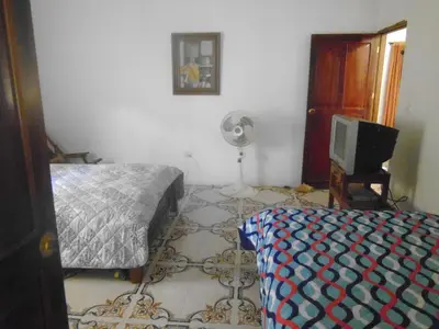 a bedroom with a bed and a fan and a tv at Hostal Santa Clara in San Antero