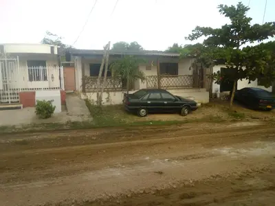 a green car parked in front of a house at Hostal Santa Clara in San Antero