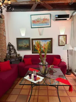 a living room with a red couch and a table at Casa Colonial Serrezuela in Cartagena de Indias