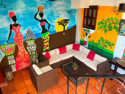 a living room with a couch and a mural at Casa Colonial Serrezuela in Cartagena de Indias