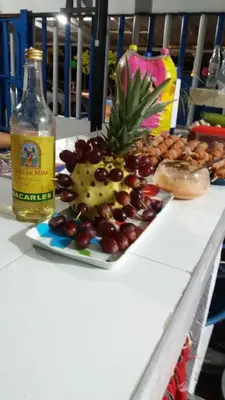 a plate of grapes and a bottle of alcohol on a table at Hotel Don Toño Tolú in Tolú