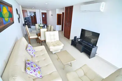 a living room with a couch and a tv at Torres del Lago Apartamentos in Cartagena de Indias