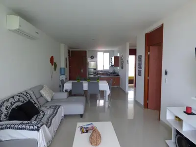 a living room with a couch and a dining room at Costa Azul Suites 401 in Santa Marta