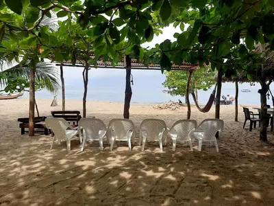 a group of chairs and tables on a beach at Casa Madrigueña in Rincón