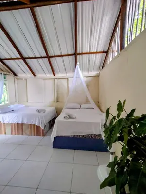 two beds in a room with a tent at Eco Hotel Campo Verde in Isla Grande