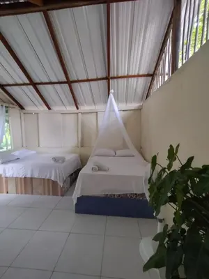 two beds in a room with a tent at Eco Hotel Campo Verde in Isla Grande