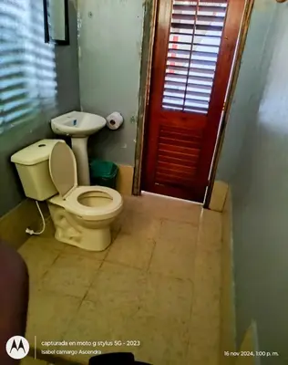 a bathroom with a toilet and a red door at Eco Hotel Campo Verde in Isla Grande