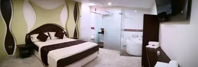a bedroom with a bed and a bathroom with a shower at Hotel Diamante Real Cienaga in Ciénaga