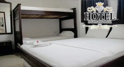 two beds in a hotel bedroom with a sign on it at Hotel Diamante Real Cienaga in Ciénaga