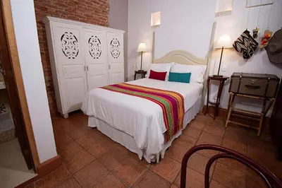 a bedroom with a large white bed with colorful pillows at Hotel Bantu by Faranda Boutique, a member of Radisson Individuals in Cartagena de Indias