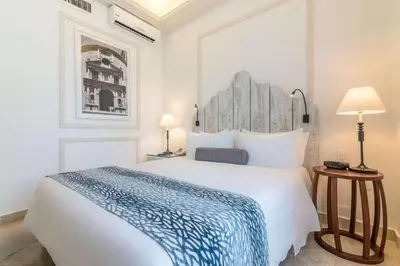 a bedroom with a large white bed and two lamps at Hotel Caribe by Faranda Grand, a member of Radisson Individuals in Cartagena de Indias