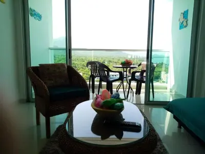a living room with a bowl of fruit on a table at Costa Azul Suites 1002 in Santa Marta