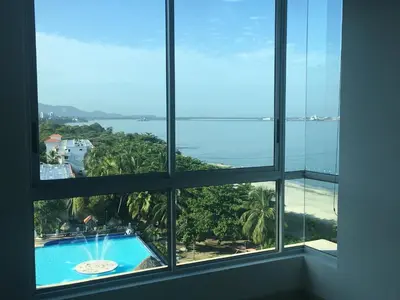 a room with windows looking out at a swimming pool at Costa Azul Suite 606 in Santa Marta