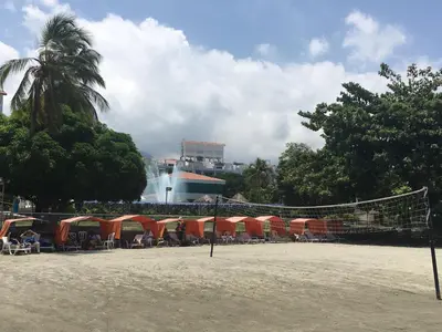 a beach with tents and a volley ball net at Costa Azul Suite 606 in Santa Marta