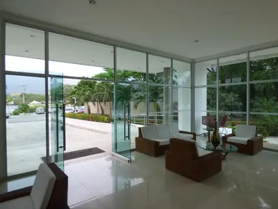 a living room filled with furniture and glass windows at Costa Azul Suites 906 in Santa Marta