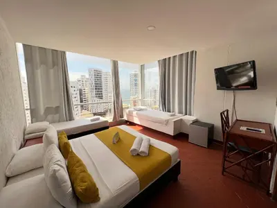 a hotel room with two beds and a large window at Hotel Costa del Sol in Cartagena de Indias