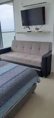 a couch in a bedroom with a flat screen tv at Morros City - Frente al mar in Cartagena de Indias