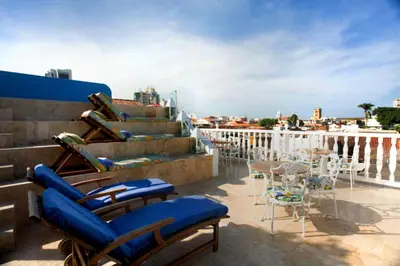 a group of chairs and tables on a balcony at Hotel Casa Quero in Cartagena de Indias