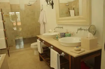 a bathroom with two sinks and a toilet and a mirror at Hotel Casa Quero in Cartagena de Indias