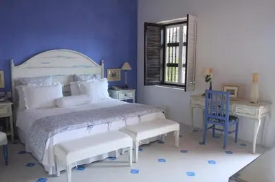 a bedroom with a bed and a table and a chair at Hotel Casa Quero in Cartagena de Indias