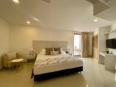 a bedroom with a bed and a desk and a television at Hotel Dorado Plaza Bocagrande - All Inclusive in Cartagena de Indias