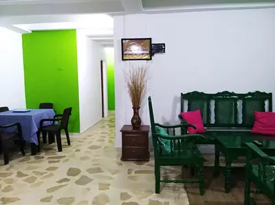 a dining room with a green table and chairs at Cabañas Cigua in Coveñas