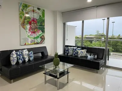a living room with two black couches and a glass table at Apartamento Cartagena Morros Epic 23 in Cartagena de Indias