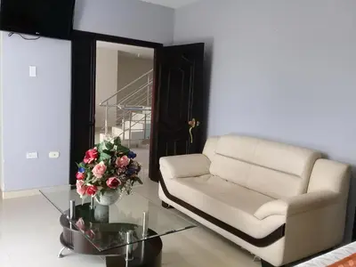 a living room with a couch and a table with flowers at Hotel Dainner in Plato