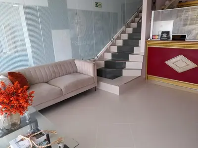 a living room with a couch and a staircase at Hotel Dainner in Plato