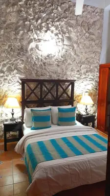 a bedroom with a bed with blue pillows on it at Casa Del Curato in Cartagena de Indias