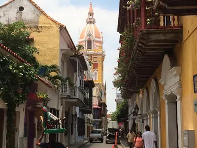 a group of people walking down a street with a clock tower at Edificio Marina del Rey Cartagena in Cartagena de Indias