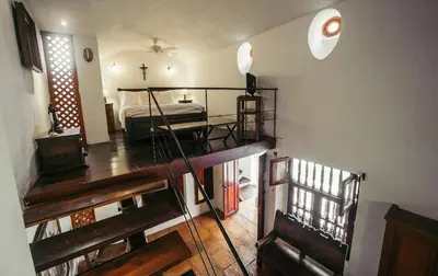 a bedroom with a bed and a cross on the wall at Alfiz Hotel in Cartagena de Indias