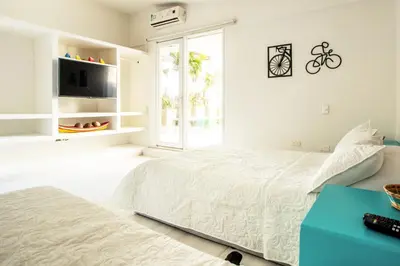 a white bedroom with a bed and a tv at Hotel Barahona Cartagena in Cartagena de Indias