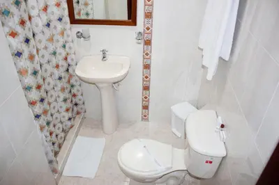 a white bathroom with a toilet and a sink at Hotel Dorado Plaza Centro Histórico in Cartagena de Indias