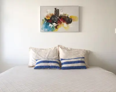 a bed with two pillows and a painting on the wall at Apartamento con hermosa vista y cerca de playas in Cartagena de Indias