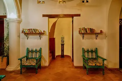 two green chairs in a room with books on shelves at Casa D´Remedios La Bella Hotel Boutique in Ciénaga