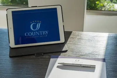 a laptop computer sitting on top of a table with a pen at Country International Hotel in Barranquilla