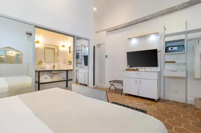 a bedroom with a bed and a flat screen tv at El Marques Hotel Boutique By GEH Suites in Cartagena de Indias