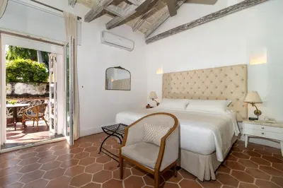 a bedroom with a bed and a chair and a patio at El Marques Hotel Boutique By GEH Suites in Cartagena de Indias