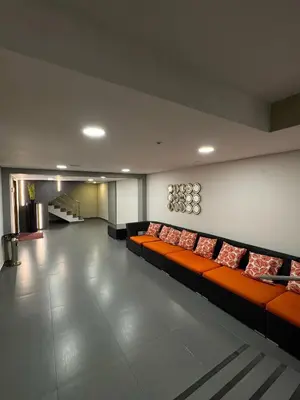 a living room with orange couches in a room at Hotel American Golf in Barranquilla