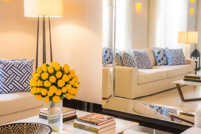 a living room with a couch and a vase of yellow flowers at Casa La Merced by Mustique in Cartagena de Indias